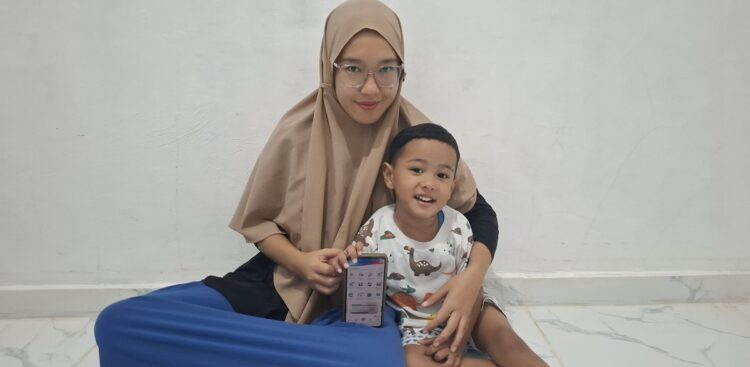 Di Luar Domisili, Balita Elia Tetap Dijamin JKN 1 MANFAAT JKN— Eldio dan ibunya saat memperlihatkan kartu kepesertaan JKN .