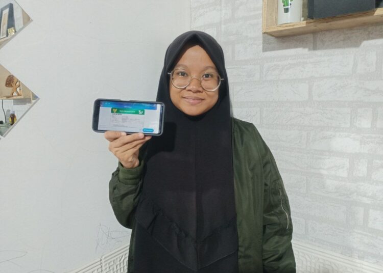 PROGRAM JKN— Puti Zakiyyah saat melihatkan kartu JKN yang dimanfaatkan semasa kehamilan hingga melahirkan.