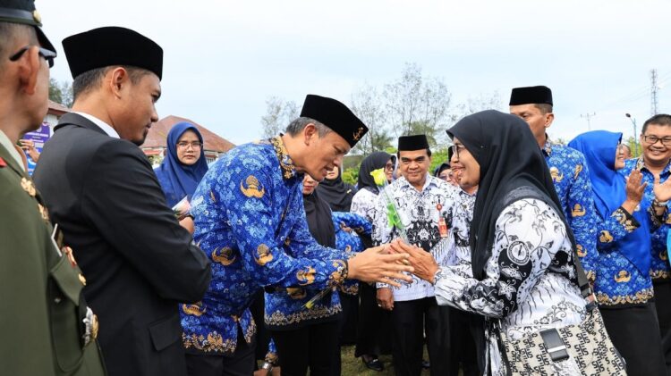 UPACARA KORPRI DAN HGN— Pj Wali Kota Pariaman Roberia memberi ucapan selamat kepada para guru usai upacara peringatan HUT Korpri dan HGN.