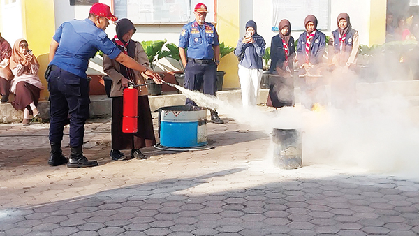 Pemadam Kebakaran Goes to School, Tenaga Pendidik dan Siswa Diajarkan Cara Padamkan Api 1 PENANGANAN KEBAKARAN— Petugas Damkar Padang mempraktikkan cara memadamkan api saat terjadi kebakaran kepada tenaga pendidik dan siswa SMP 8 Padang, Kamis (13/2).