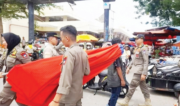 PENERIBAN PKL— Personel Satpol PP Padang mengangkut sejumlah payung-payung milik PKL saat melakukan penertiban terhadap pedagang yang melanggar aturan di sejumlah kawasan, Selasa (18/2).