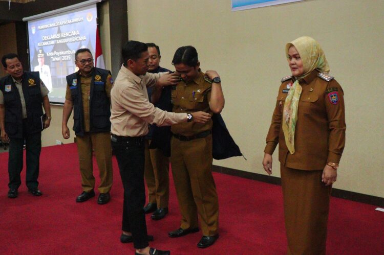 PASANGKAN ROMPI KENCANA— Ketua DPRD Kota Payakumbuh Wirman Putra saat memasangkan rompi Kencana kepada Camat Payakumbuh Barat Ul Fakhri.