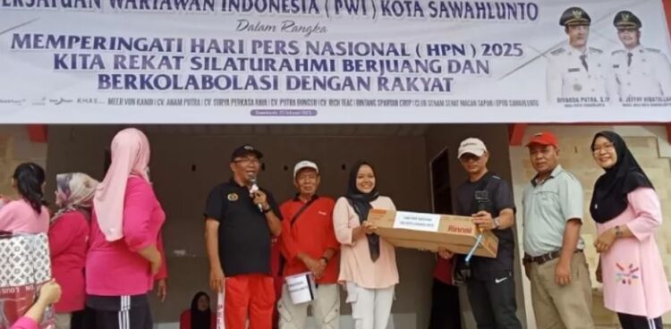 Senam Massal Warnai Hari Pers di Sawahlunto 1 SERAHKAN DOORPRIZE— Ketua PWI Sawahlunto Indra Yosep Datmy menyerahkan door prize kepada salah seorang peserta senam massal.