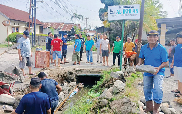Ambruk, Warga Perbaiki Talud Banda Penahan Jalan Raya Pisang 1 PERBAIKAN TALUD PENAHAN JALAN— Lurah Pisang Adek Deswarman bersama warga, RT, RW, LPM, Babinsa dan Bhabinkamtibmas goro melakukan perbaikan talud penahan jalan raya Pisang yang rusak, di di simpang Parakkarambia RT 02/RW III, Minggu (16/2),