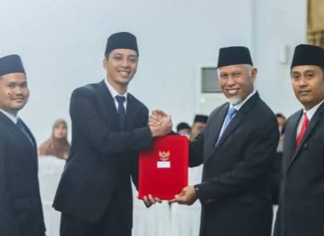 SERAHKAN—Gubernur Sumatera Barat Mahyeldi Ansharullah saat menyerahkan  Surat Keputusan (SK) pelantikan sebagai Kepala Daerah dari Kemendagri untuk Walikota Sawahlunto Riyanda Putra dan Wakil Walikota Sawahlunto  di kantor Gubernur , Kamis (6/3).