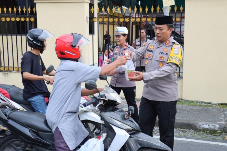 Polres Pasbar Bagi-bagi Takjil 1 BAGIKAN TAKJIL— Kapolres Pasaman Barat AKBP Agung Tribawanto membagikan takjil kepada warga dan juga pengendara di depan Mapolres Pasbar, kemarin.