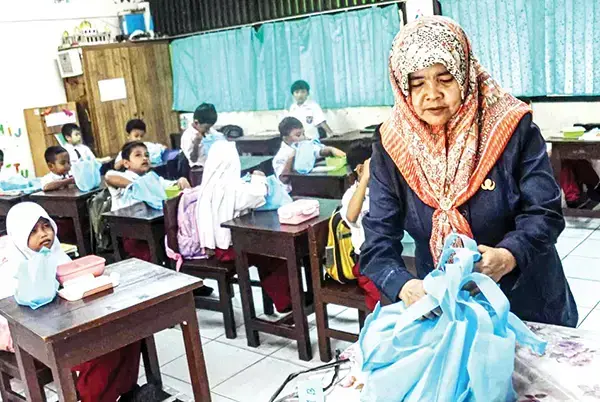 Walau Banyak Dikritik, Program Makan Bergizi Gratis Presiden Prabowo Dianggap Mulia 1 MAKAN BERGIZI GRATIS— Guru membagikan menu Makan Bergizi Gratis (MBG) khusus bulan Ramadhan di SDN 15 Slipi, Jakarta.