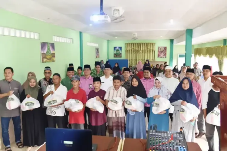 PEMBAGIAN PAKET SEMBAKO—Kepala Bagian Perekonomian dan Kesejahteraan Rakyat (Kabag Kesra) Sekretariat Daerah Kota Pariaman, Delri Soni, foto bersama dengan Baznas serta penerima zakat.