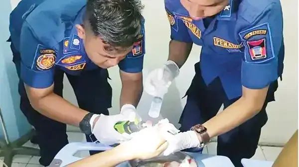 LEPASKAN CINCIN— Petugas Damkar Kota Padang membantu korban Rifki (18), pegawai toko roti, untuk melepaskan cincinnya, di RSUP M Djamil Padang, Senin (14/4).