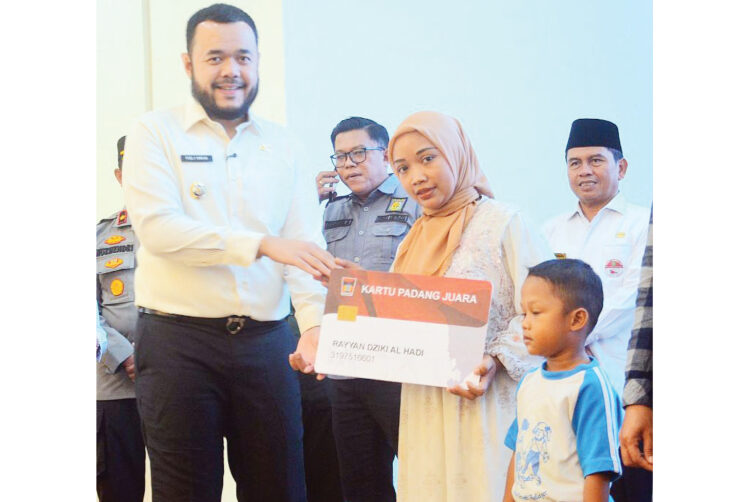 Wako Fadly Amran Luncurkan Kartu Padang Juara, 17.710 Siswa Terima Seragam dan 16.208 Siswa Dapat LKS Gratis 1 KARTU PADANG JUARA— Wali Kota Padang, Fadly Amran, menyerahkan Kartu Padang Juara kepada siswa kelas 1 Sekolah Dasar (SD) dari keluarga yang tergolong dalam Data Terpadu Kesejahteraan Sosial (DTKS) dan Masyarakat Berpenghasilan Rendah (MBR), Rabu (21/5), Bagindo Azis Chan Youth Center.