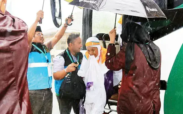 Hujan Deras dan Badai Warnai Kedatangan Jamaah Kloter 6, Petugas Embarkasi Padang Basah Kuyup Payungi Jamaah 1 PAYUNGI JAMAAH— Petugas Penyelenggara Ibadah Haji (PPIH) Embarkasi Padang menyambut kedatangan jemaah di Asrama Haji, dengan payung dan kondisi baysah kuyup, Minggu (11/5). Senin (12/5), jemaah haji kloter 6 ini sudah diberangkatkan dari BIM menuju Medinah.