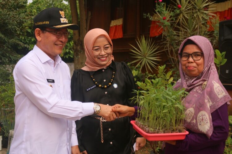 Wali Kota Serahkan Bantuan Bibit Tanaman kepada KWT 1 SERAHKAN BANTUAN BIBIT— Wali Kota Payakumbuh Zulmaeta bersama Ketua TP PKK Ny. Eni Muis Zulmaeta menyerahkan bantuan bahan bibit dan benih tanaman kepada Kelompok Wanita Tani (KWT) se Kota Payakumbuh di KWT Lumbuang.
