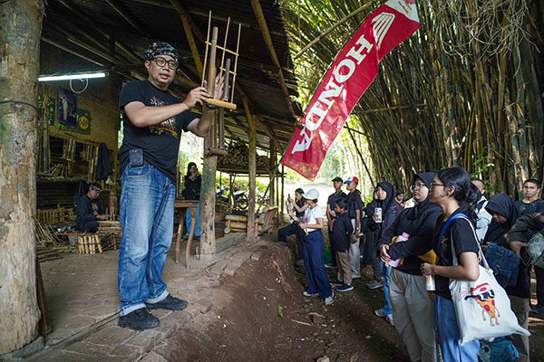 AHM Gandeng Puluhan Sekolah Jaga Warisan Budaya Indonesia 1 PEMBUATAN ANGKLUNG-Peserta School Camp 2025 secara antusias menyaksikan proses pembuatan angklung di workshop Saung Angklung Udjo.