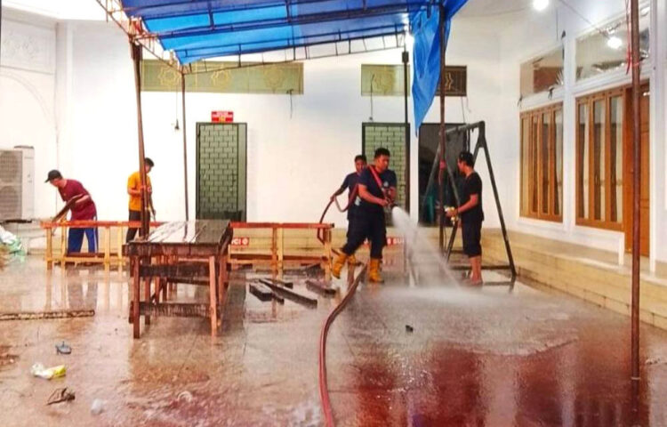 BANTUAN DAMKAR— Petugas Damkar Kota Padang ikut membantu membersihkan lantai masjid dan mushallah disejumlah wilayah usai pemotongan dan pembagian sapi kurban, Sabtu (7/6).