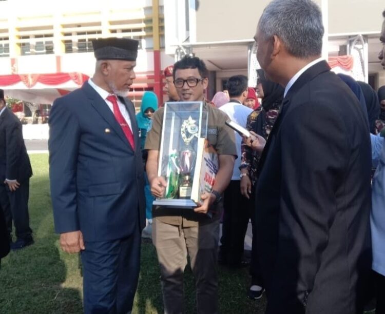 SERAHKAN—Gubernur Sumbar Mahyeldi menyerahkan piala juara 1 kepada Kota Payakumbuh sebagai daerah kategori inovasi TTG