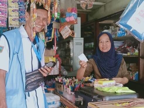 PUNGUTAN RETRIBUSI— Petugas sedang melakukan pemungutan retribusi kebersihan door to door pada pedagang.