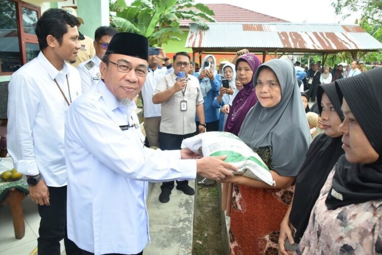 1.120 KK di Kelurahan Kuranji Terima Bantuan Pangan Beras 1 BANTUAN PANGAN BERAS— Wakil Wali Kota Padang Maigus Nasir bersama Pemimpin Perum Bulog Wilayah Sumbar Darma Wijaya, menyerahkan bantuan pangan beras kepada warga penerima manfaat, Rabu (30/7), di Halaman Kantor Kelurahan Kuranji, Kecamatan Kuranji.