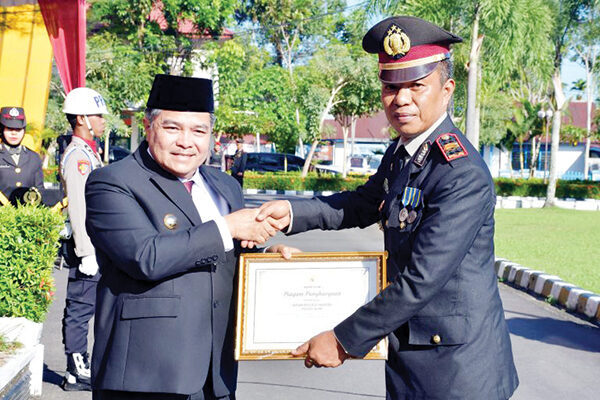 Komitmen Berantas Narkoba, Bupati Beri Penghargaan Kepada Satres Narkoba Polres Agam 1 KOMITMEN BERANTAS NARKOBA— Bupati Agam,
Benni Warlis memberikan piagam penghargaan kepada
Satres Narkoba Polres Agam, yang diterima langsung
oleh Kasat Narkoba, Iptu Herwin, usai upacara
peringatan HUT Bhayangkara ke-79, di halaman
Kantor Bupati Agam, Selasa (1/7).