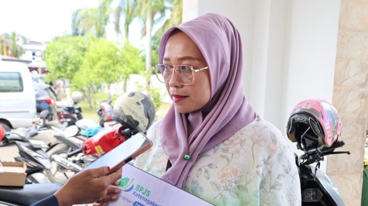 TERIMA SANTUNAN— Nofitriani (41), ahli waris dari almarhum Rizal Effendy usai terima santunan jaminan kematian dari BPJS Ketenagakerjaan kerja sama Pemerintah Kota Pariaman.