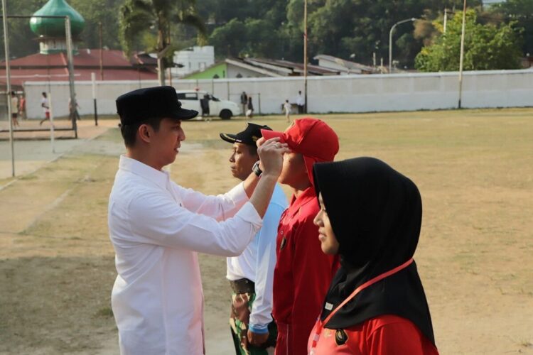 PEMUSATAN LATIHAN— Wali Kota Sawahlunto Riyanda Putra, memasangkan tanda peserta saat membuka kegiatan pemusatan latihan Pasukan Pengibar Bendera (Paskibra) Kota Sawahlunto di Lapangan Ombilin.