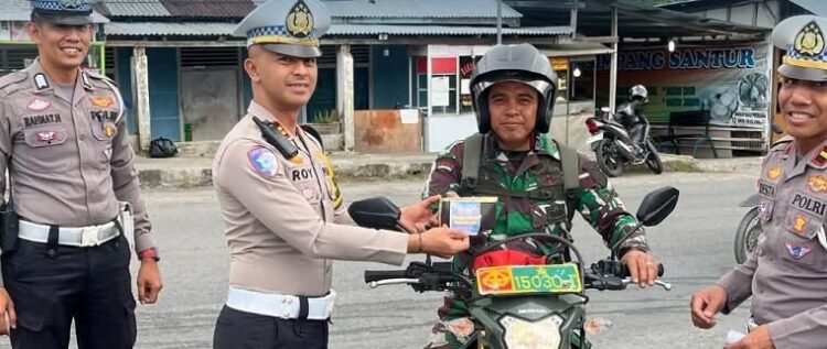 SERAHAN—Kasat Lantas Polres Sawahlunto Iptu Roy Capri Tiskartono, serahkan reward pada pengendara sepeda motor yang merupakan anggota TNI AD.