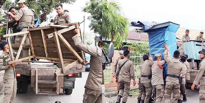 Teguran Satpol PP Dicuekin, Belasan Lapak PKL Dibongkar 1 PENERTIBAN LAPAK PKL— Tim Gabungan Satpol PP Kota Padang, menertibkan belasan lapak-lapak PKL yang berjualan di atas trotoar dan badan jalan, di kawasan Air Tawar Barat, jalan Chendrawasih Kecamatan Padang Utara hingga jalan Jhoni Anwar, Kecamatan Nanggalo, Sabtu (23/8) pagi.