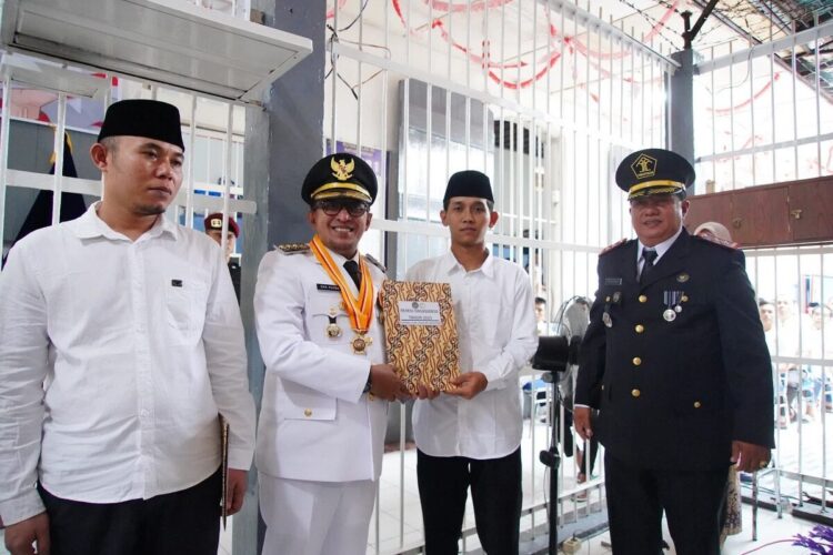 84 Warga Binaan Rutan Kelas II B Batusangkar Terima Remisi Kemerdekaan 1 SERAHKAN REMISI— Bupati Eka Putra didampingi Kepala Rutan Batusangkar Elfiandi menyerahkan SK remisi pada salah seorang warga binaan.