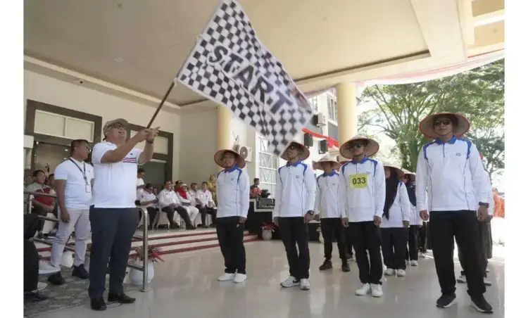 Pakaian Unik Hingga Yel-Yel, Semangat Sambut Gerak Jalan Santai Antar OPD 1 BENDERA STAR—Sekretaris Daerah Dr. H. Syamsurizaldi angkat bendera star dimulainya acara.