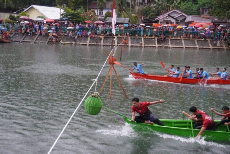 Hujan Deras, Penonton Final Selaju Sampan Tetap Semangat 1 FINAL SELAJU SAMPAN— Hujan deras yang mengguyur Kota Padang tak menyurutkan semangat warga untuk menyaksikan final Selaju Sampan di kawasan Palinggam, Padang, Minggu (10/8). Sejak siang, kawasan tersebut dipadati penonton yang antusias memberi dukungan kepada tim kebanggaannya. Sorak-sorai dan tepuk tangan terus menggema di sepanjang tepi Sungai Batang Arau yang menjadi lokasi perlombaan.
