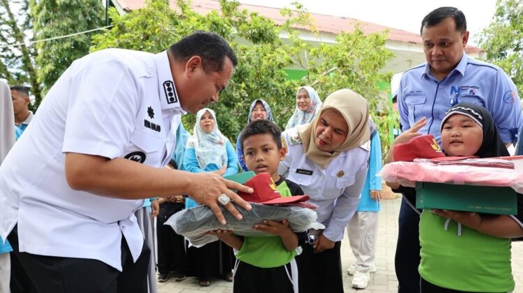 SERAHKAN SERAGAM SEKOLAH—Wali Kota Pariaman Yota Balad lagi  saat menyerahkan seragam sekolah gratis bagi siswa kelas satu (1) di Sekolah Dasar Negeri di empat kecamatan yang ada di Kota Pariaman, kemarin.