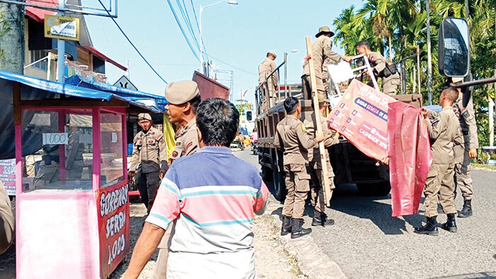 JUALAN DI TROTAR— Petugas Satpol PP bersama pihak kecamatan makin gencar melakukan razia dan penertiban PKL yang berjualan di badan jalan dan trotoar, Senin (22/9). Sejumlah lapak dan barang dagangan yang ditinggal PKL diamankan dalam penertiban.