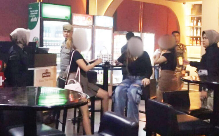 PENERTIBAN TEMPAT HIBURAN MALAM— Petugas Satpol membubarkan pengunjung beberapa tempat hiburan malam yang melanggar jam tayang yang telah ditentukan, Sabtu (27/9) dini hari. petugas menemukan lima kafe dan tempat hiburan yang masih beroperasi hingga pukul 03.30 WIB, jauh melewati batas waktu yang diizinkan, yakni pukul 02.00 WIB.