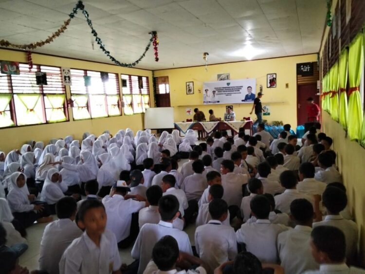 BAGIKAN SARAPAN— Roni Richardo membagikan snack, susu dan roti pada para siswa dan guru, sebagai penganti sarapan pagi.