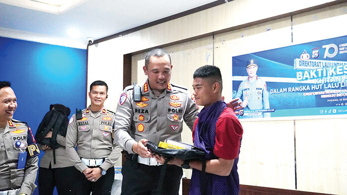 BAKTI KESEHATAN—Dirlantas Polda Sumbar, Kombes Pol H M Reza Chairul Akbar Sidiq menyerahkan bingkisan kepada peserta sunatan massal yang digelar dalam rangka HUT Lantas ke-70.