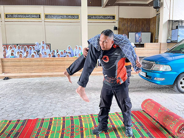 MITIGASI BENCANA— Petugas Badan Penanggulangan Bencana Daerah (BPBD) peragakan  cara memikul korban saat kegiatan sosialisasi mitigasi bencana.