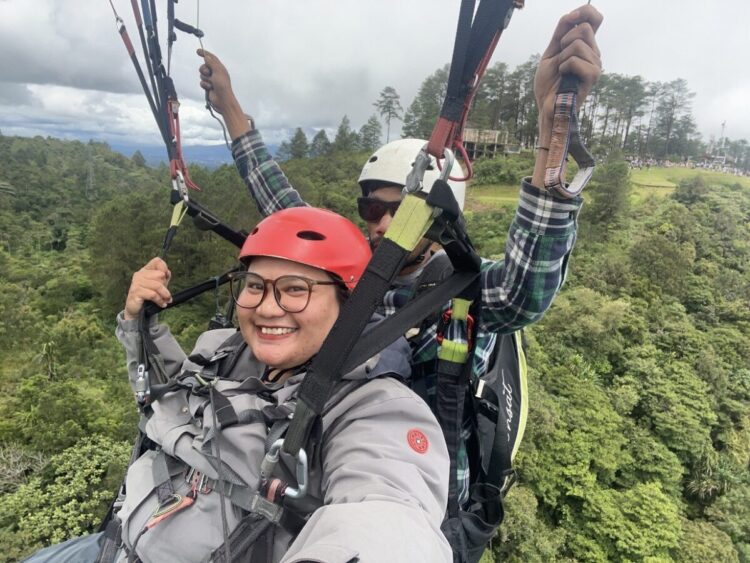 SENSASI LAYANGAN GANTUNG—Monica Wareza, saat menikmati indahnya alam dari atas layang gantung.
