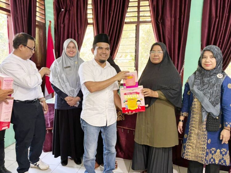 SERAHKAN BANTUAN MAKANAN BERGIZI— Wakil Bupati Solok saat mengunjungi Nagari Paninggahan bersama anggota DPD RI Muslim M Yatim menyerahkan bantuan makanan bergizi bagi balita.