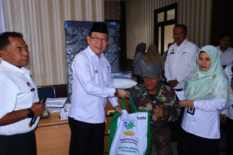 SERAHKAN BANTUAN— Wali Kota Payakumbuh, Zulmaeta, menyerahkan secara langsung bantuan Asistensi Rehabilitasi Sosial (ATENSI) Tahap II dari Kementerian Sosial RI kepada salah satu penerima manfaat di Kantor Dinas Sosial Payakumbuh