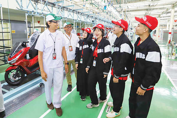 KUNJUNGI PABRIK— Edwin Sholeh Rahmanullah, GM Product Quality Engineering PT AHM, Ahmad Muhibbuddin, GM Corporate Communication PT AHM, bersama para finalis AHM Best Student 2025 saat mengunjungi pabrik perakitan sepeda motor Honda di Deltamas.