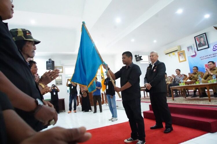 PENYERAHAN PATAKA— Ketua AWI Tanahdatar Farid Alkausar menyerahkan pataka organisasi usai pengukuhan pengurus periode 2025-2029 pada Musda I AWI, di Aula Kantor Bupati Tanah Datar, Pagaruyung, Selasa (30/9)