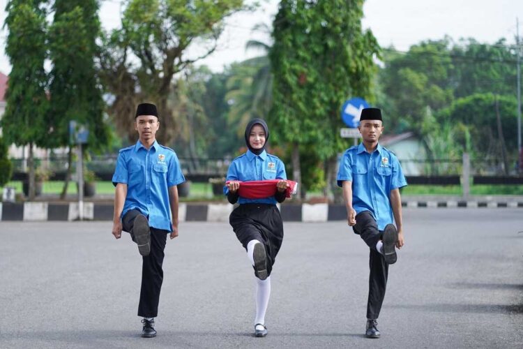 PERINGATAN SUMPAH PEMUDA— Tiga orang penggerek bendera merah putih dengan gagahnya melangkah ke tiang bendera dalam peringatan Hari Sumpah Pemuda ke 97, yang digelar di Halaman Balai Kota Solok, Selasa (28/10).