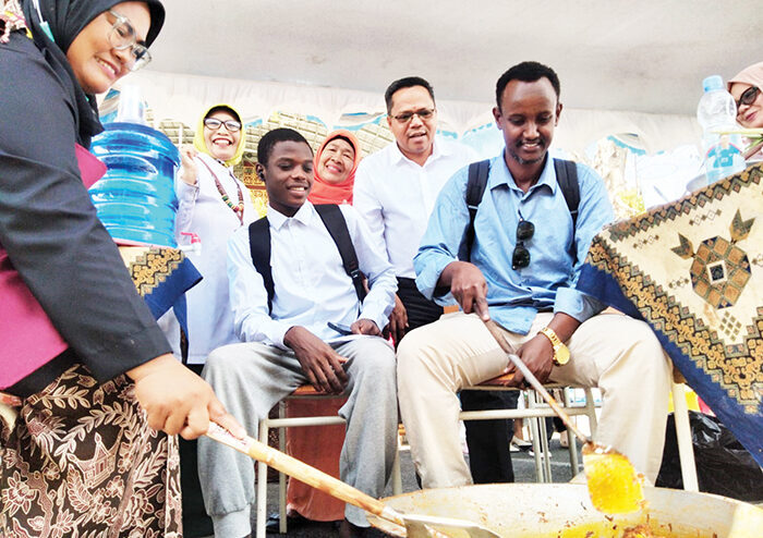 Pertama di Dunia, UNP Gelar Lomba Marandang dan Teh Telur Tingkat Kampus 1 MARANDANG— Dekan FMIPA UNP Prof. Dr. Yulkifli, S.Pd, M.Si menjelaskan ke dua orang mahasiswa asing cara mengaduk rendang. Acara ini untuk memperingati Dies Natalis ke-71 UNP.