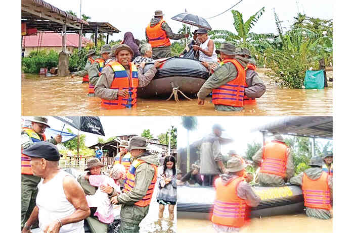 EVAKUASI— Personel Brimob Polda Sumbar mengevakuasi warga yang terjebak bencana banjir.