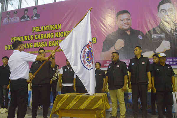 PENYERAHAN BENDERA PATAKA— Ketua harian Pengprov KBI Sumbar  Fazril Ale menyerahkan bendera pataka kepada Ketua Pengcab KBI Kota Padang periode 2025-2029, M Tommy Arby Rumengan.