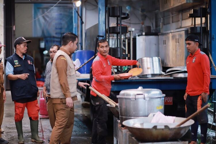 Wali Kota Solok Tinjau Dapur Umum, Pastikan Ketersediaan Makanan bagi Warga Terdampak Banjir 1 PANTAU DAPUR UMUM— Wali Kota Solok Dr. Ramadhani Kirana Putra saat memantau dapur umum yang beroperasi di Kantor Dinas Sosial Kelurahan Tanah Garam. Wako memastikan dapur umum bisa membantu menyediakan makanan bagi pengungsi dan warga terdampak bencana.