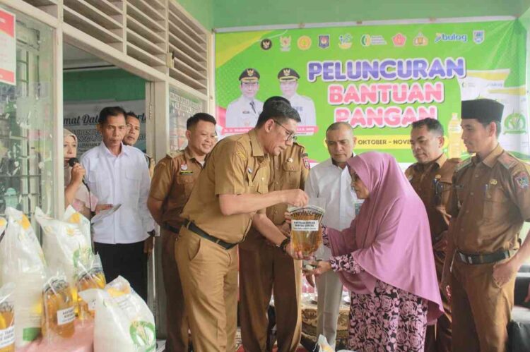 BANTUAN PANGAN—Wali Kota Payakumbuh yang diwakili Asisten II Yasrizal saat berikan bantuan pada warga.
