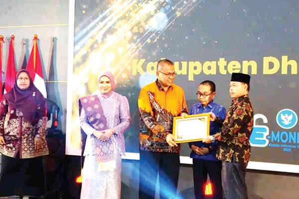 TERIMA PENGHARGAAN— Sekretaris Dinas Kominfo Dharmasraya, Hendri saat terima piagam penghargaan.