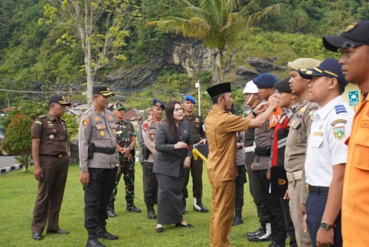 Polres Padang Panjang Bersiap Hadapi Bencana Hidrometeorologi 1 APEL KESIAP SIAGAAN— Wawako Padang Panjang Allex sematkan pita peserta saat Apel Kesiapan Tanggap Darurat Bencana Hidrometeorologi di halaman Mako Polres, Rabu (5/11).