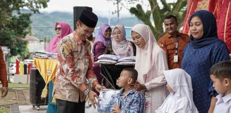SERAHKAN SERAGAM—Wakil Bupati Solok Selatan H. Yulian Efi  menyerahkan seragam gratis di Kecamatan Sungai Pagu, Kamis (20/11).