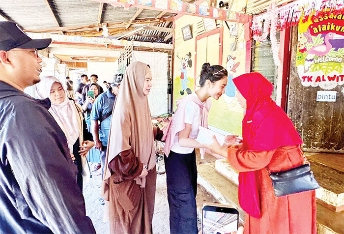 SALURKAN BANTUAN— Azizah, putri Wakil Ketua Komisi VI DPR RI Andre Rosiade, turun langsung ke Kota Padang, Sabtu (29/11), untuk menyalurkan bantuan bagi korban terdampak.